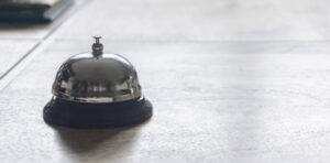 silver table bell on light wooden background dfasfsd